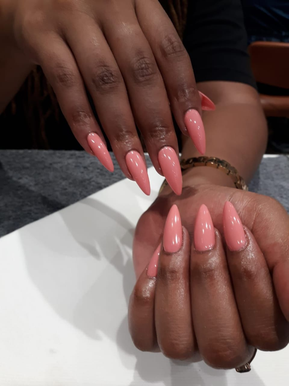 Glossy soft gel tips in a peach pink stiletto finish