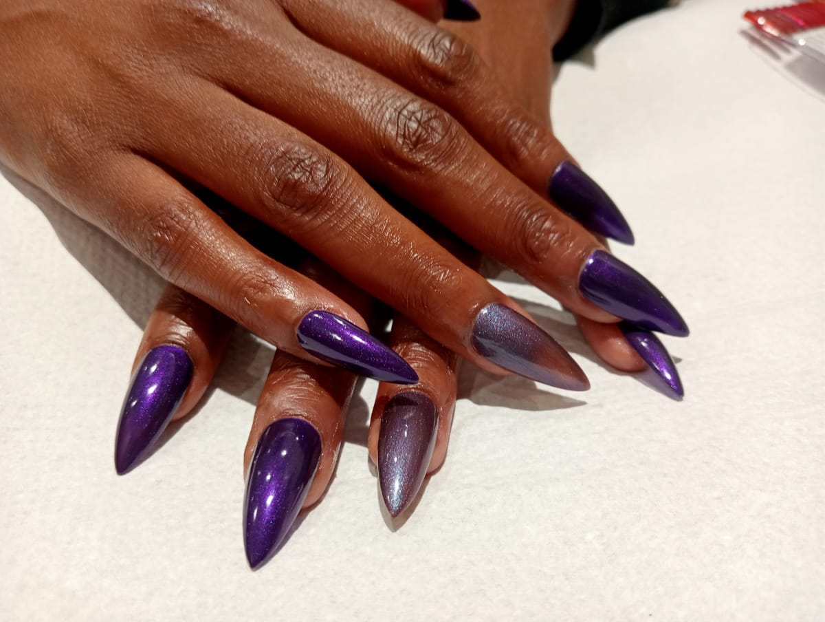 Glossy purple chrome soft gel tips in a stiletto finish