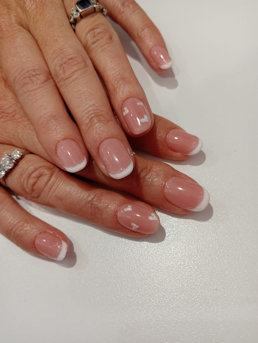 Elegant nude gelish manicure with white French tips and silver hearts